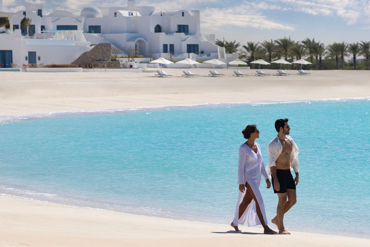 Anantara Santorini Abu Dhabi (1) A Couple Strolling Down The Beach At Anantara Santorini Abu Dhabi